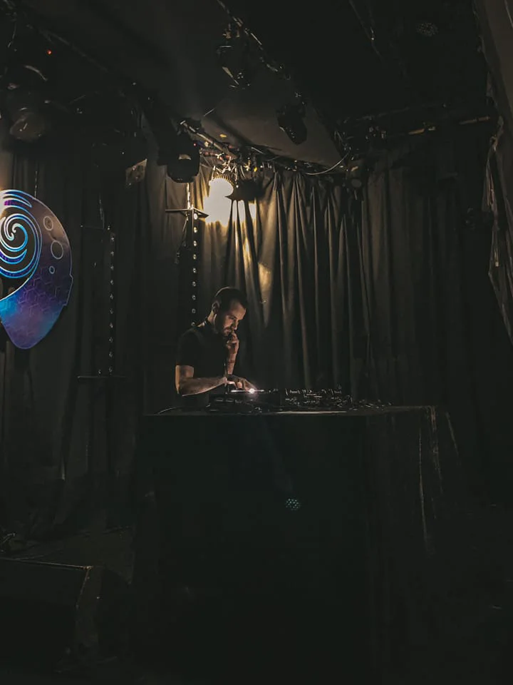 AlesK performing in a dark club space