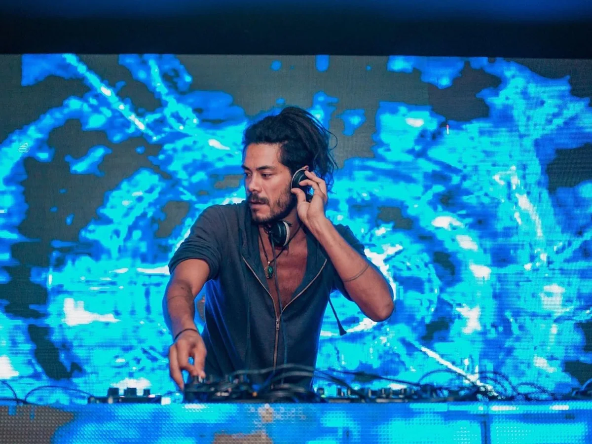 Satrip performing in front of a blue psychedelic visual