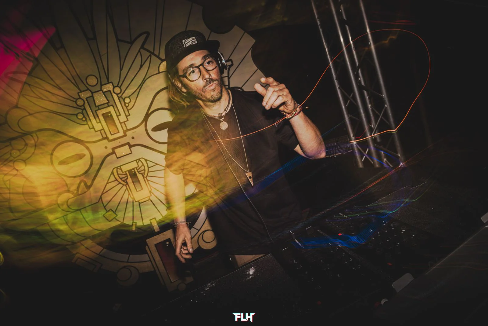 Trippy Fry performing behind DJ equipment with long-exposure light trails